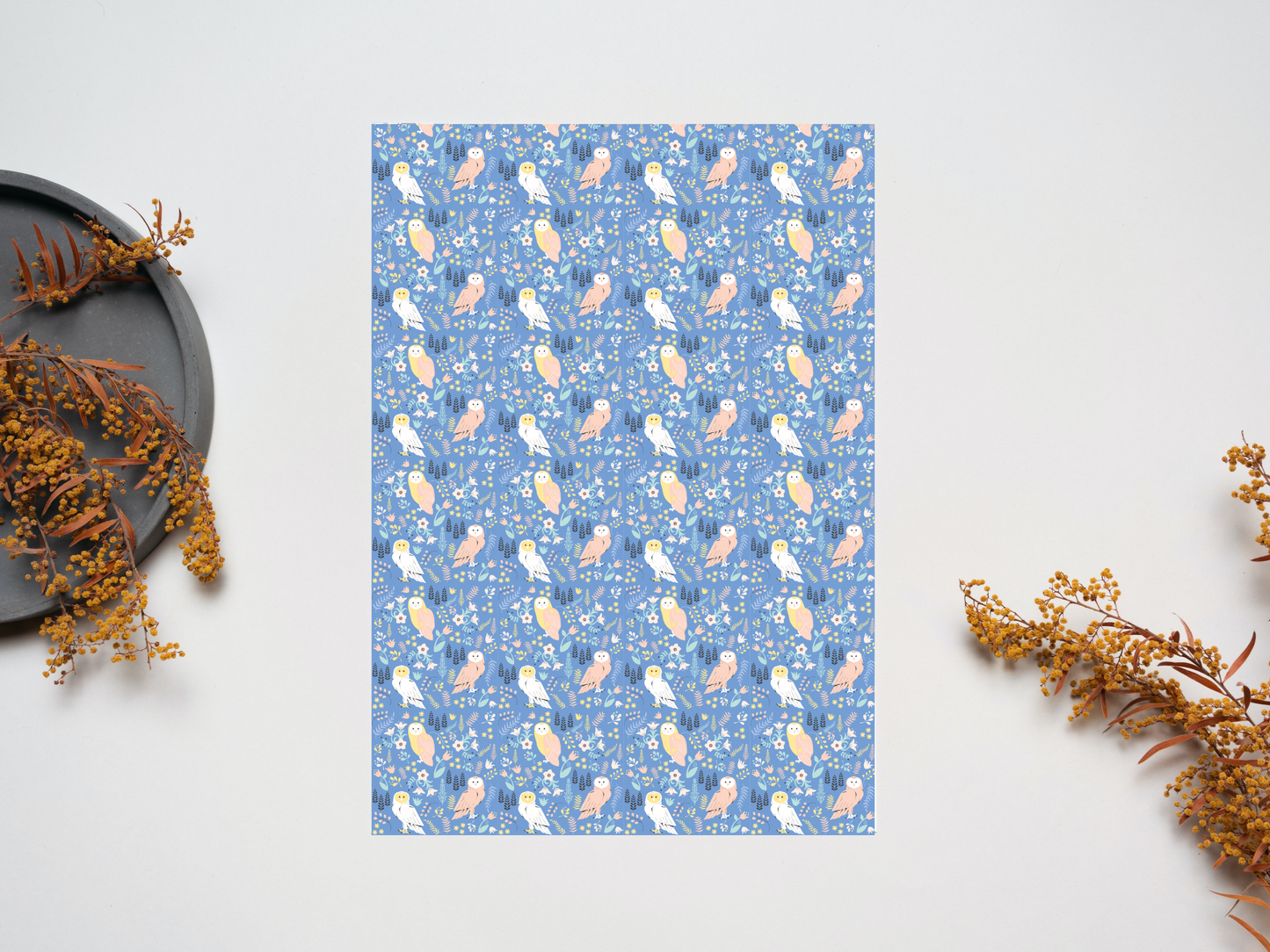 Owls dollhouse wallpaper on a table near dry leaves