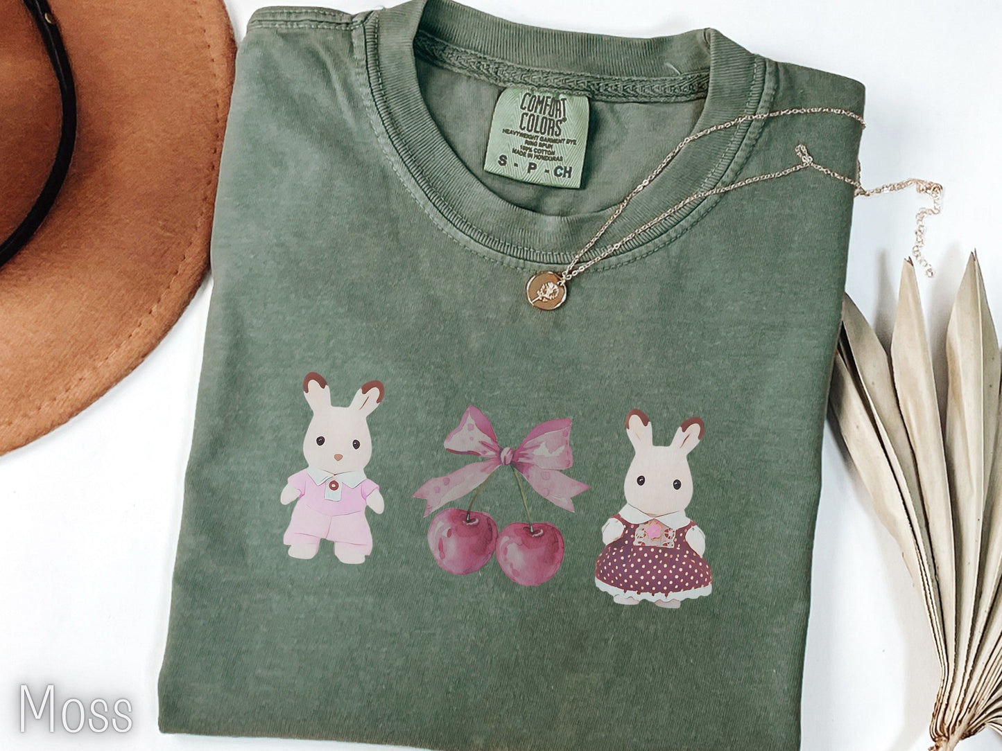 Folded green t-shirt with cartoon characters on a white background