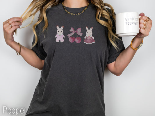 Person wearing a dark gray t-shirt with graphic designs, holding a mug.