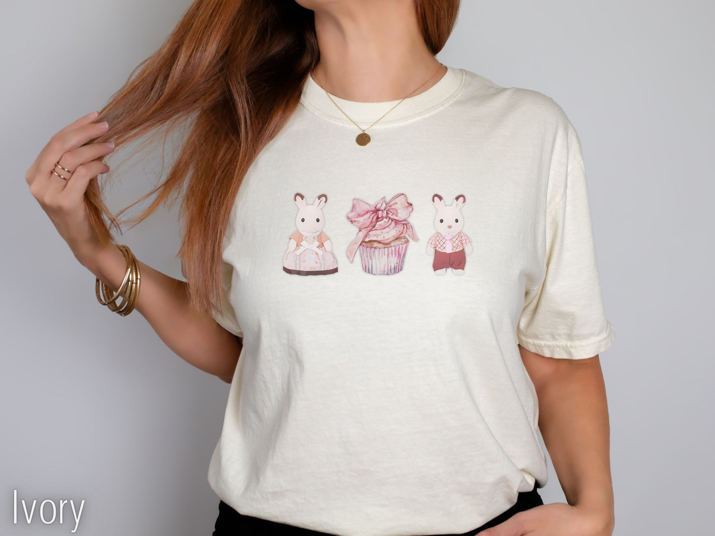 Ivory t-shirt with cartoon designs worn by a person on a plain background