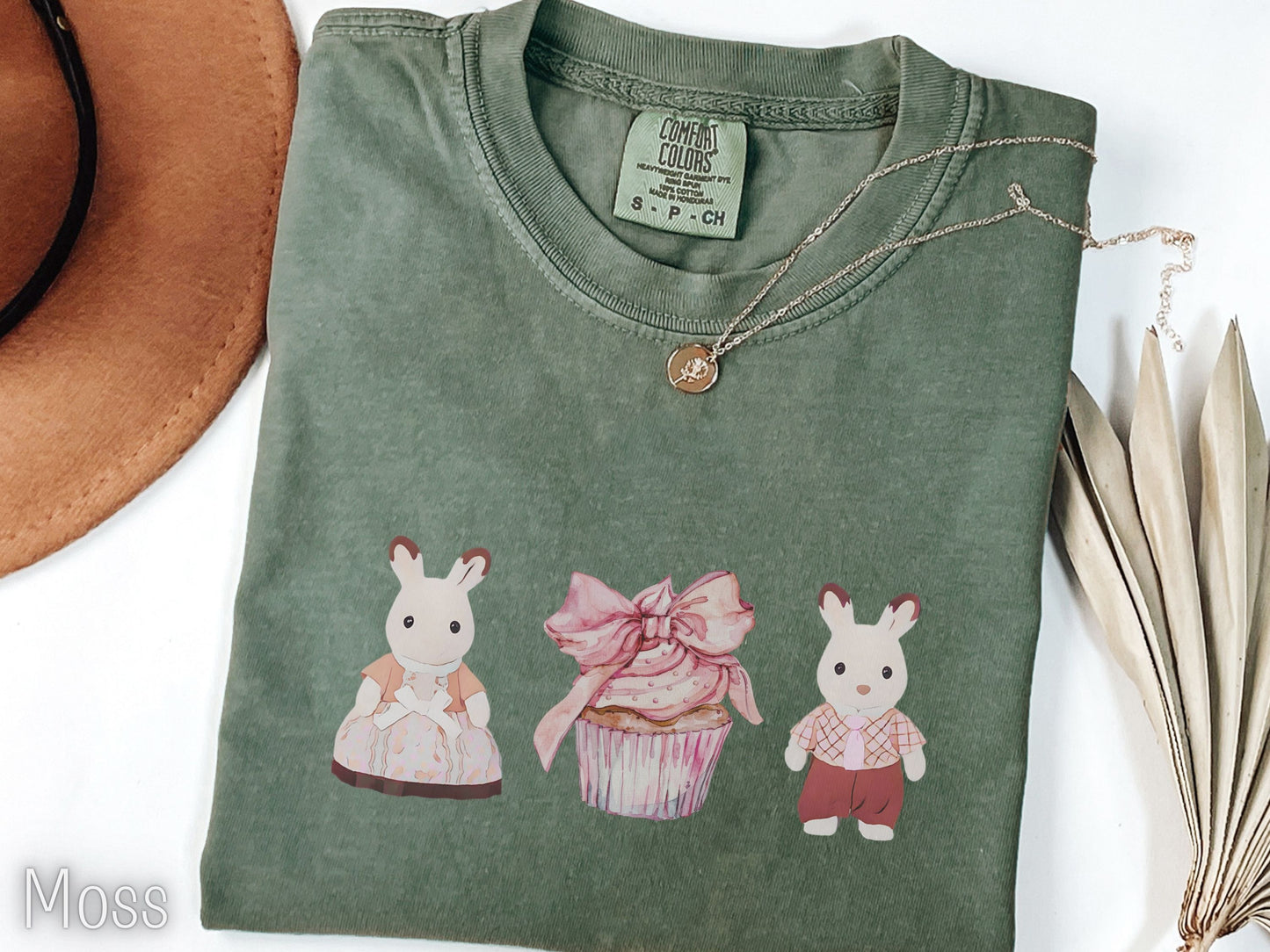 Folded green t-shirt with cartoon characters on a white background