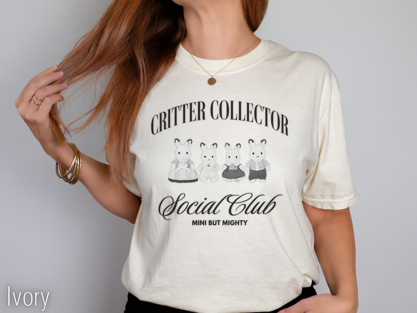 Person wearing a white t-shirt with 'Critter Collector Social Club' design on a plain background