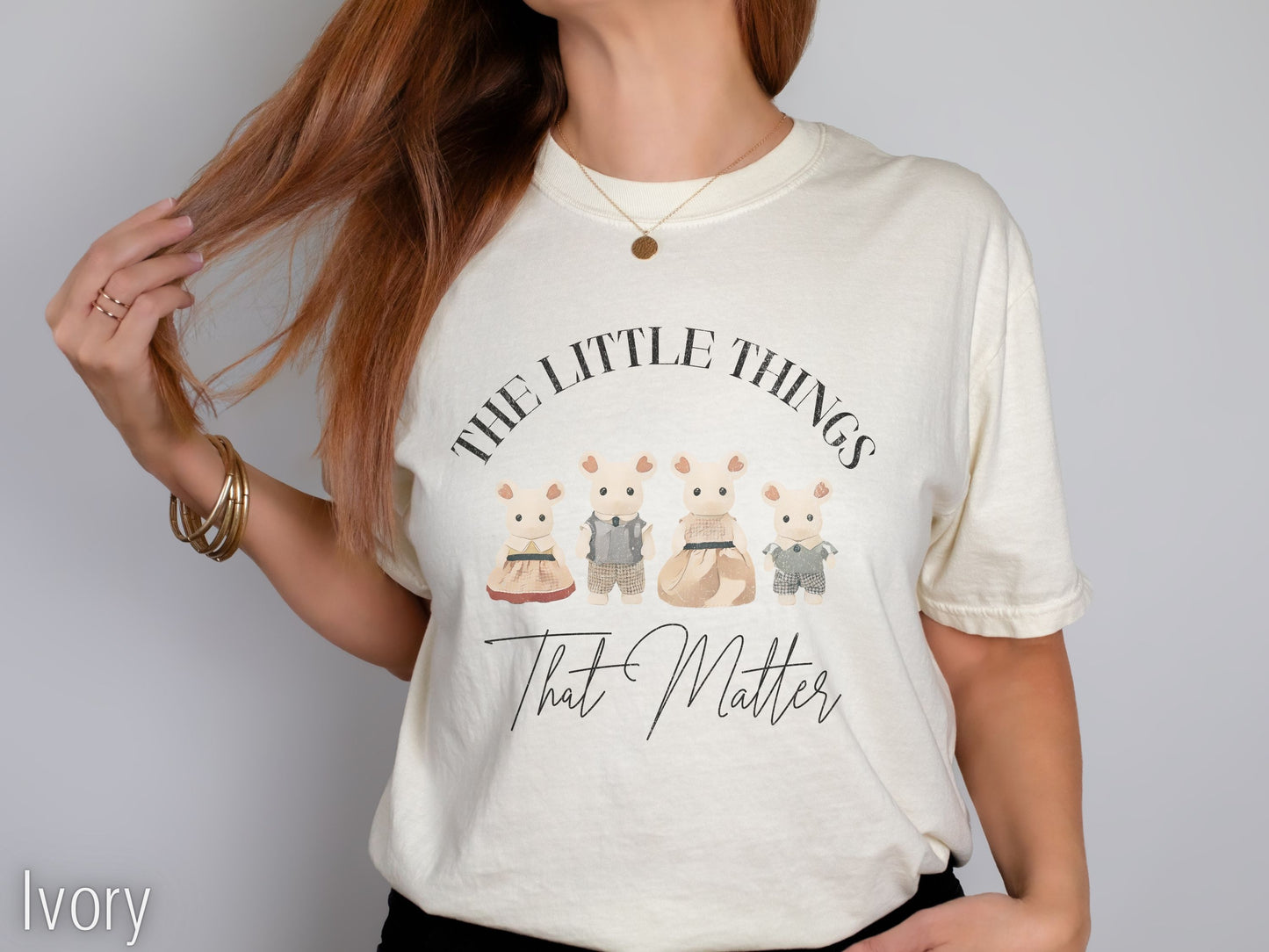 Person wearing an ivory t-shirt with cartoon bears and text on a plain background