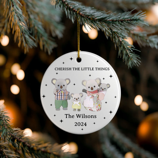 Round Christmas ornament with calico critters koalas and text 'Cherish the Little Things' on a tree branch.