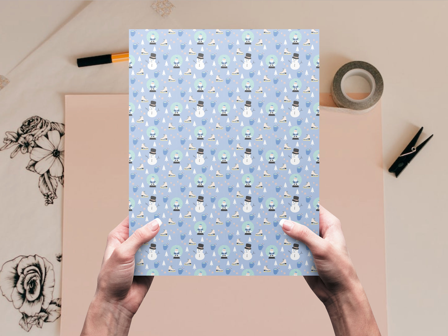 The Snowman and Snow Globe dollhouse wallpaper is held by a woman above a desk
