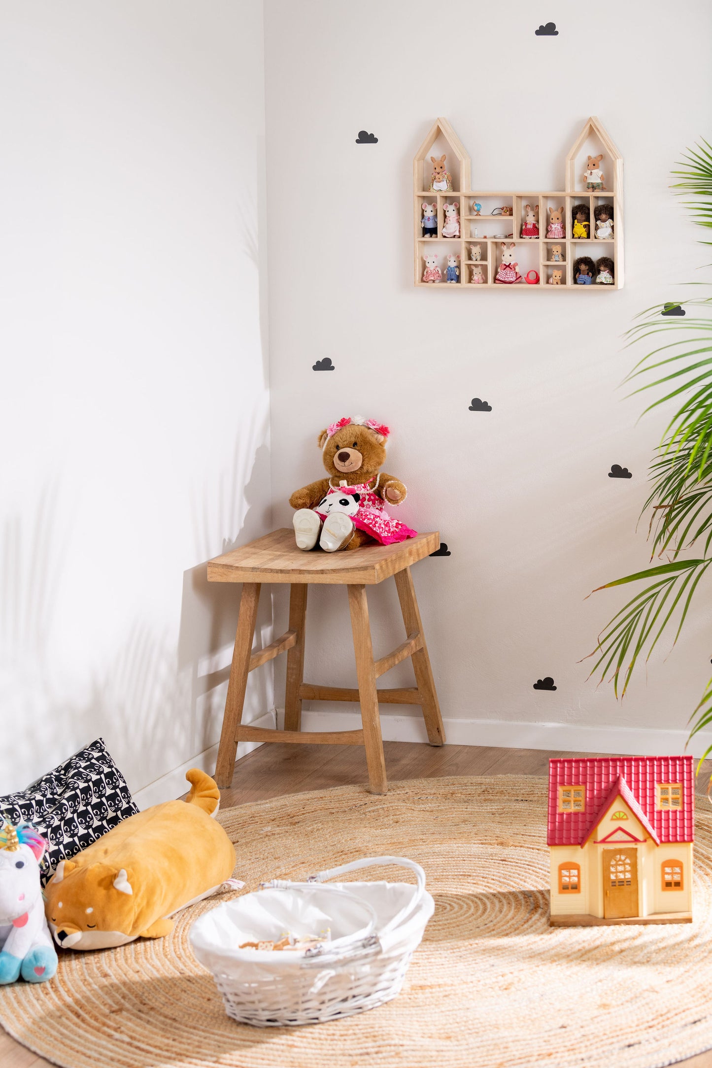 A girl's room with a  castle-shaped wooden toy display shelf that is hung on the wall with Calico Critters.