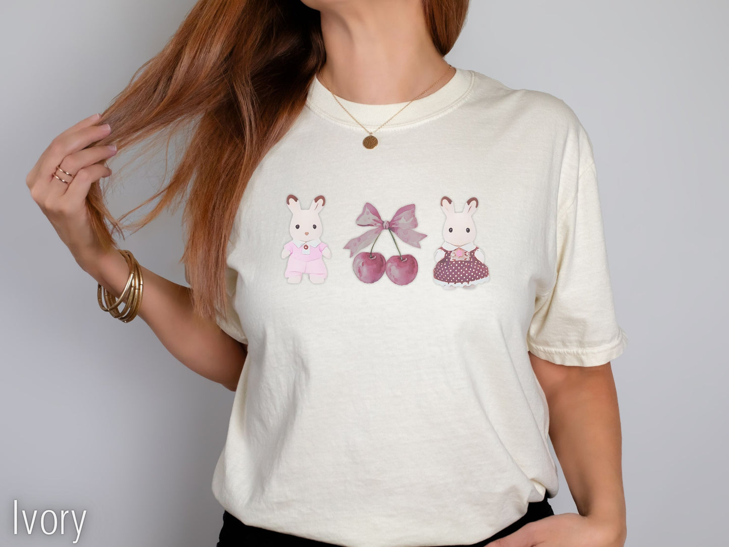Ivory t-shirt with decorative elements worn by a person on a plain background