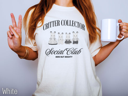 Person wearing a white t-shirt with 'Critter Collector Social Club' design, holding a white mug.