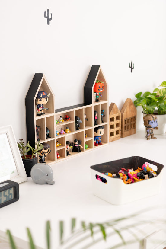 POP figures and angry birds are displayed on a castle-shaped wooden toy display shelf standing on a table