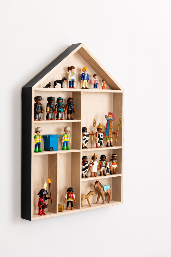 Playmobil figures are displayed in a house shaped wooden shelf with black painted outer walls