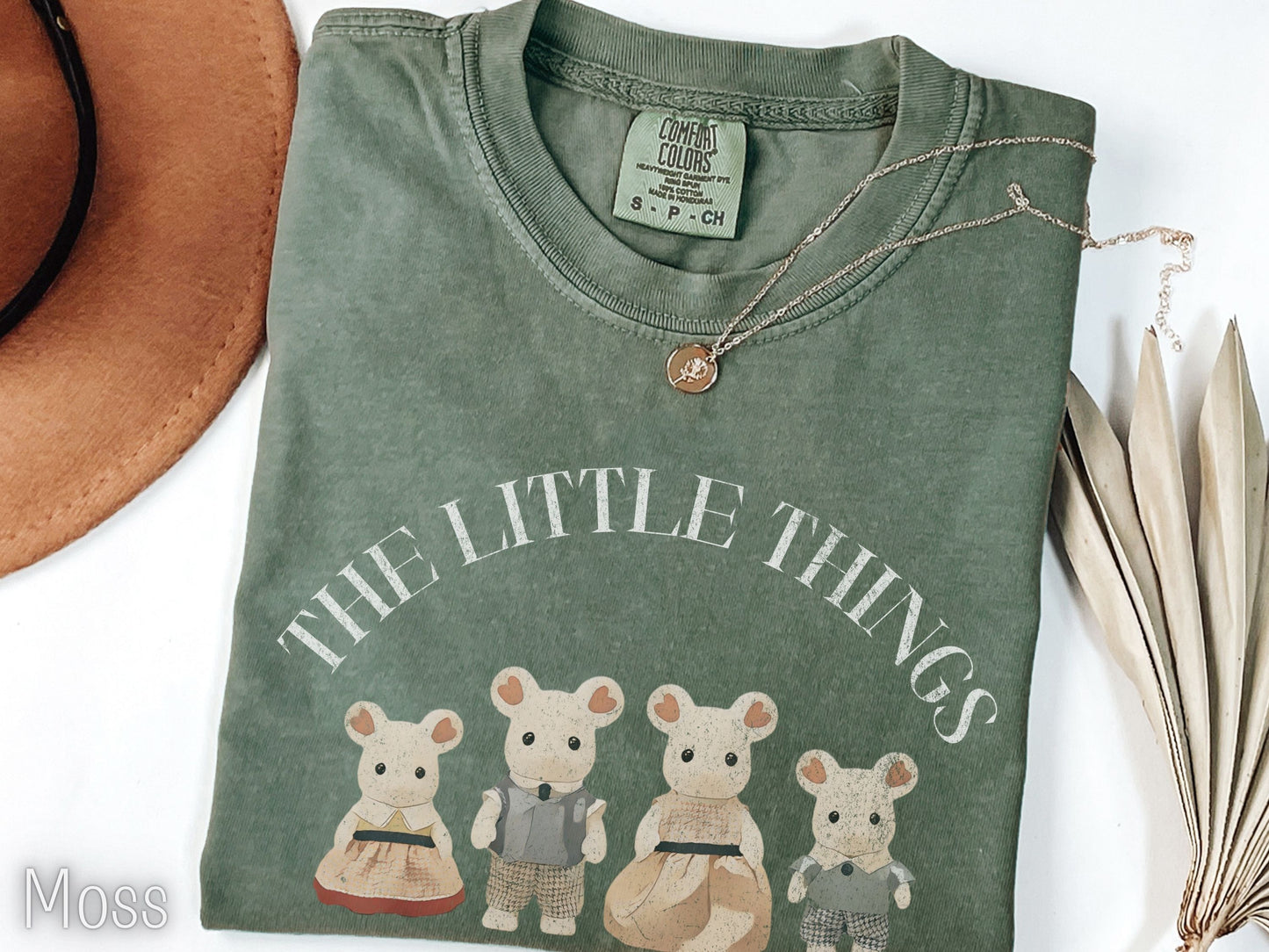 Green t-shirt with 'The Little Things' text and bear illustrations on a white background