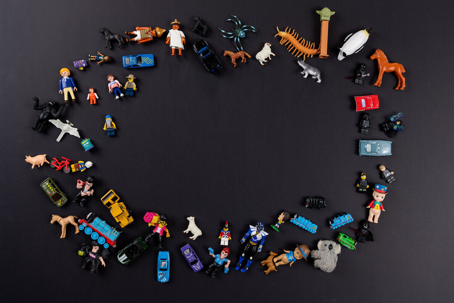 Small toys are scattered in a circle shape with black background