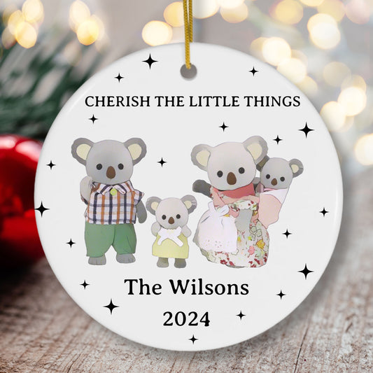 Decorative Christmas ornament with cartoon koalas and text 'Cherish the Little Things' on a white background.