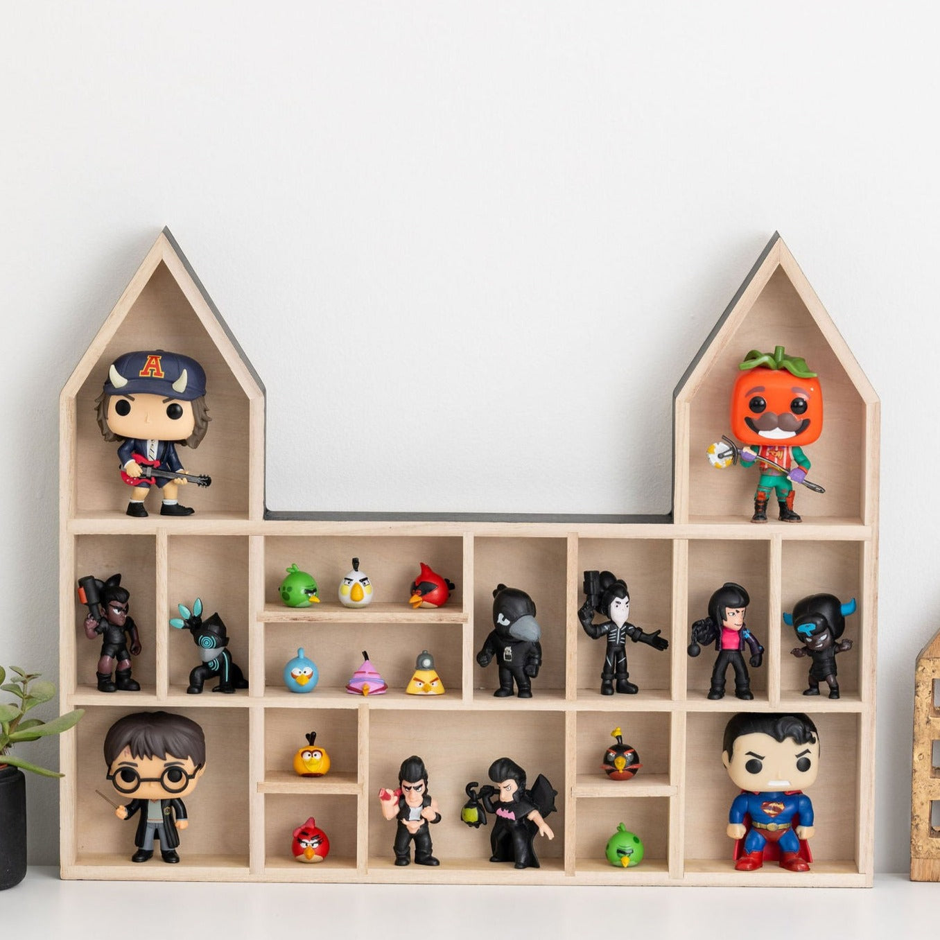 Closeup on a castle shaped wooden toy display shelf with Funko POP!  Angry Birds and Brawl Stars mini figures.