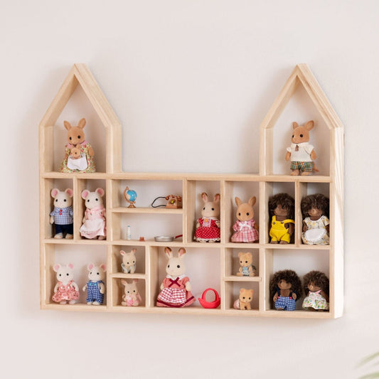 A castle-shaped wooden toy display shelf with Calico Critters display hung on the wall