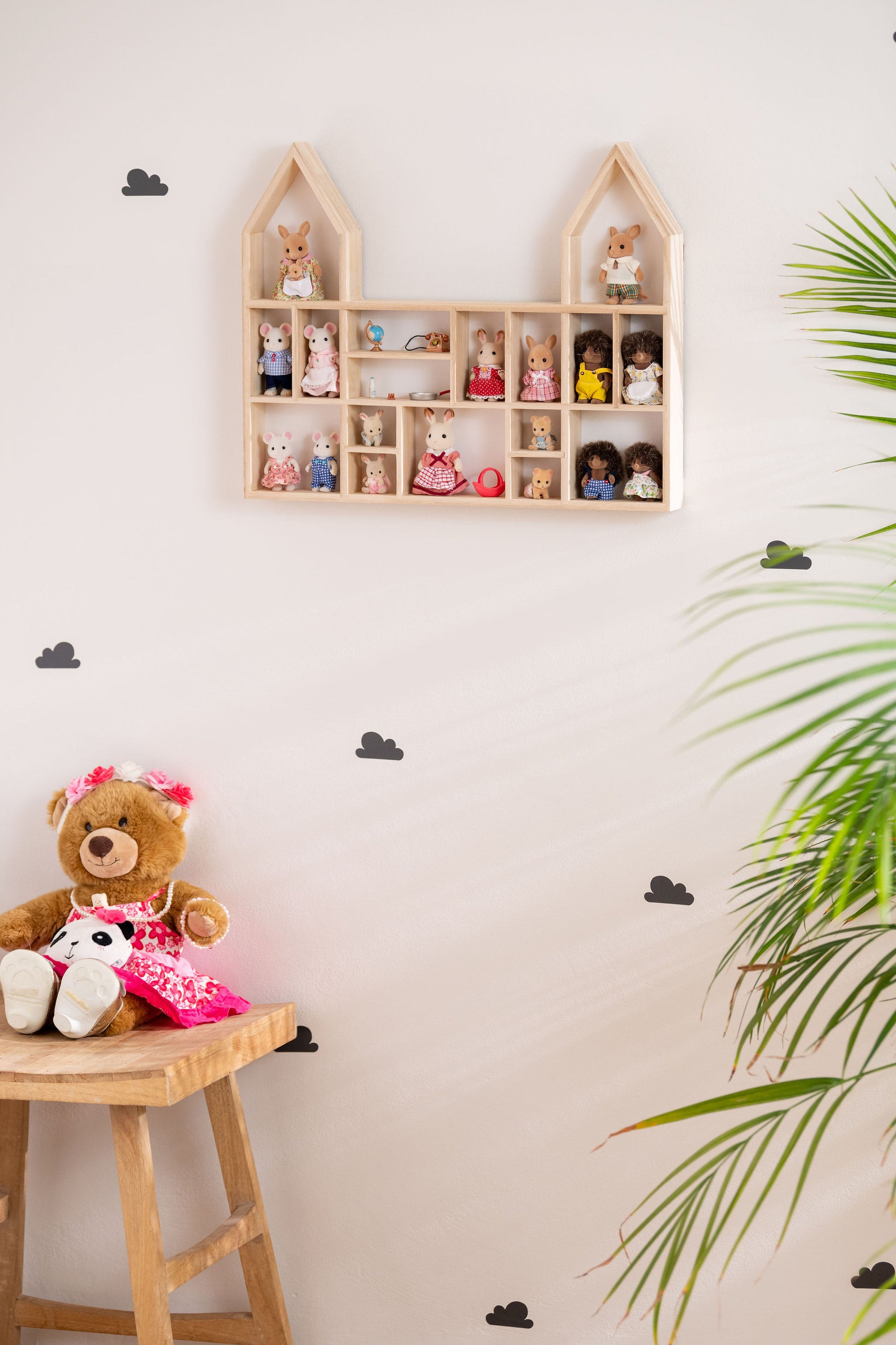 A castle-shaped shelf with a Calico Critters display hung on the wall