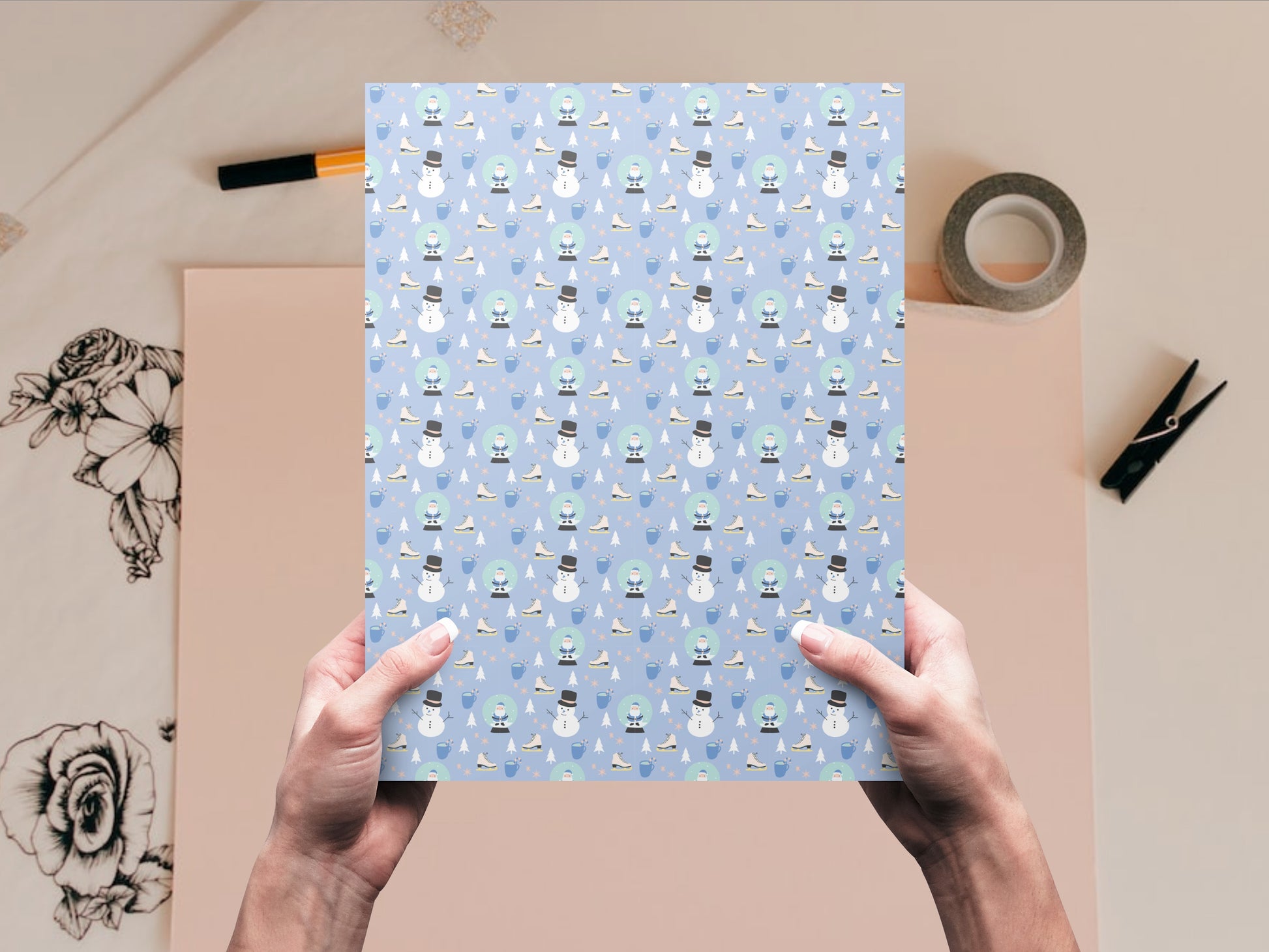 The Snowman and Snow Globe dollhouse wallpaper is held by a woman above a desk