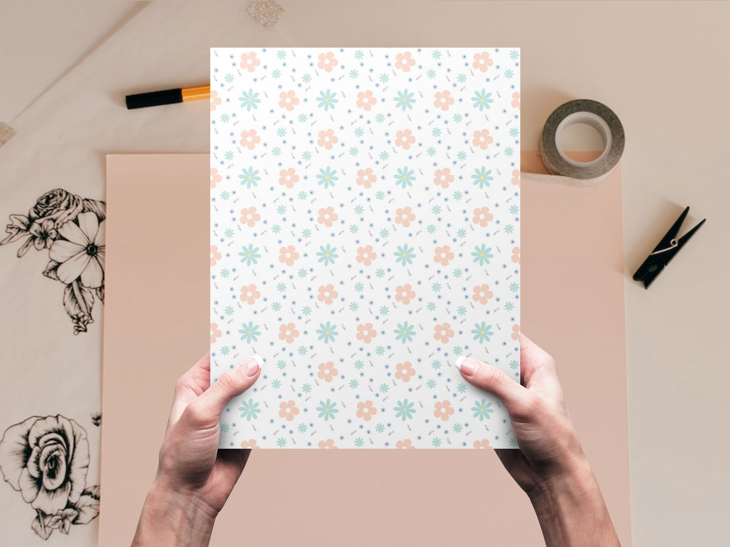 The dollhouse wallpaper pattern of flowers in pastel colors is held by a woman above a desk
