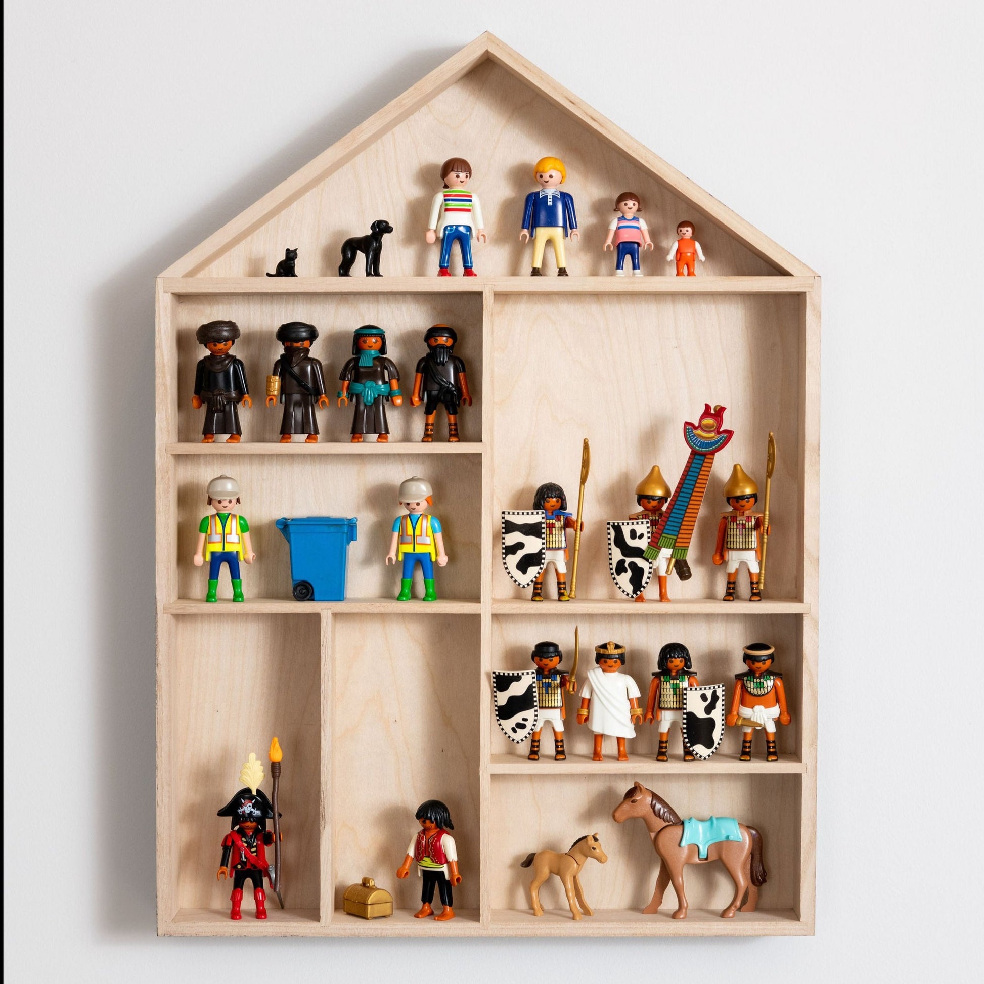 Front view closeup on a house-shaped wooden toy display shelf with Playmobil figures.